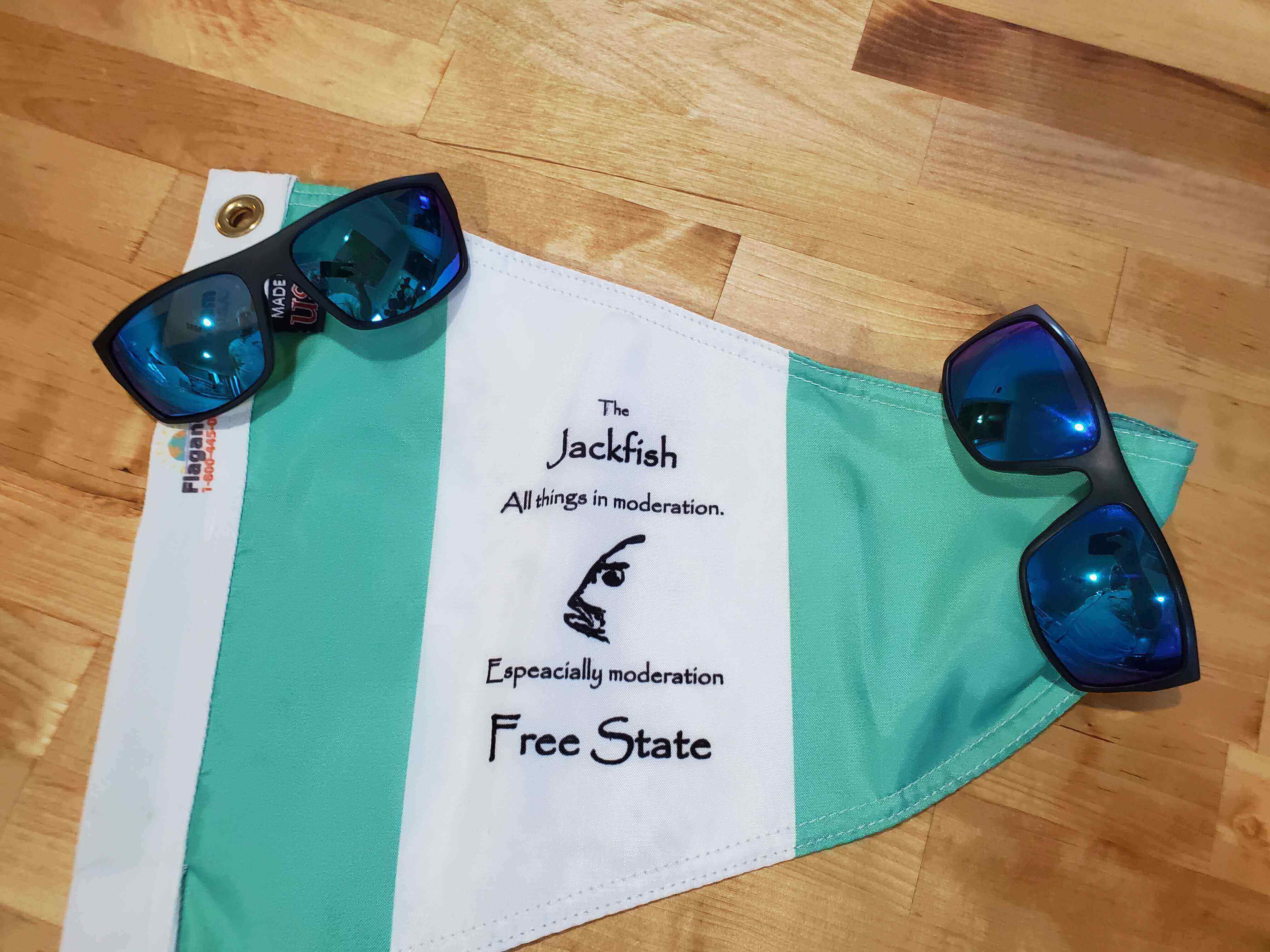 A pair of sunglasses and a towel on the floor.