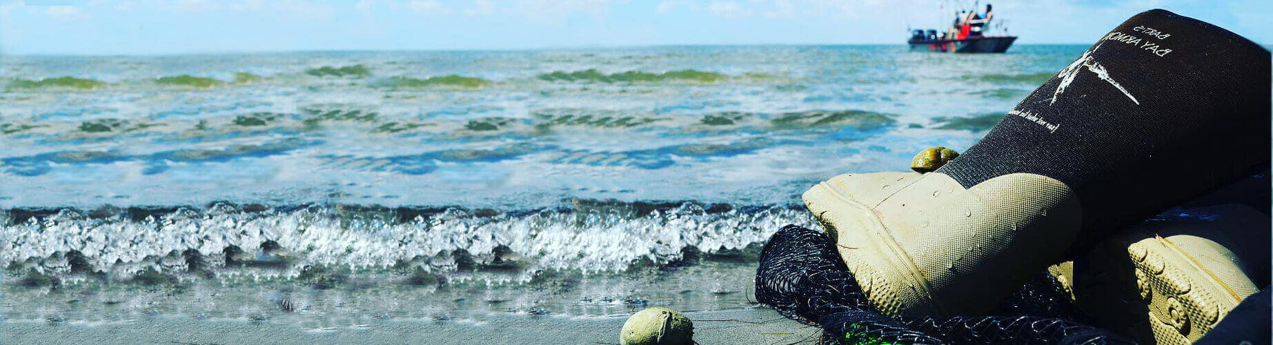 A person standing on the beach next to some water