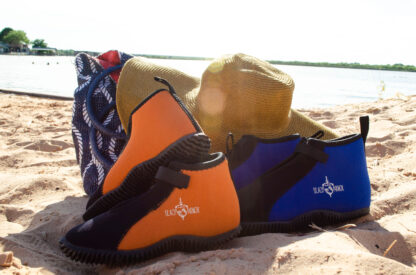 A pair of shoes and hat on the beach.