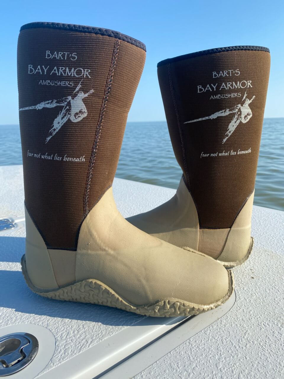 Neoprene fishing boots beside open water